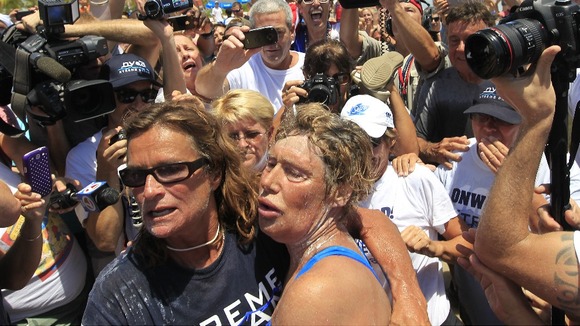 Diana Nyad collapses into her friend's arms as she completes her 110-mile journey.