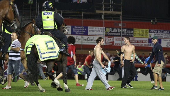Mounted police work to clear fans from the potch