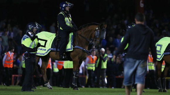 Mounted police respond to a pitch invasion at Ashton Gate, Bristol