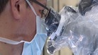 Surgeon looking into a microscope