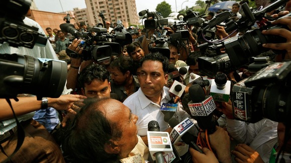 The defence lawyer for one of the defendants, A.P. Singh, surrounded by media outside the court