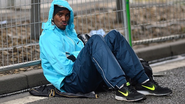 Mo Farah pouts for the cameras as he shelters from the rain.