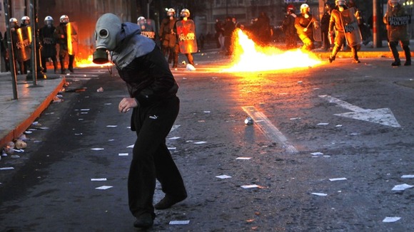 A protester runs away from police during a violent anti-austerity demonstration in central Athens