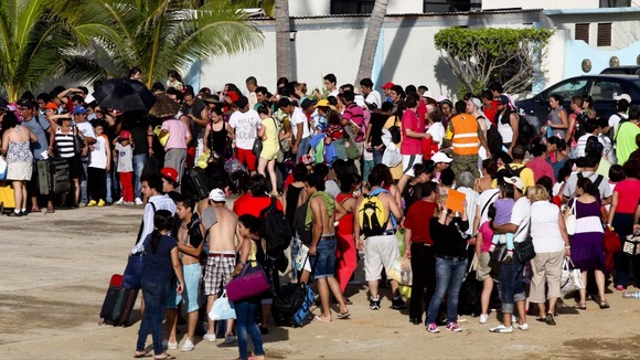 People stand in line while waiting to be airlifted by Mexico's Secretariat of National Defense out of Acapulco yesterday.