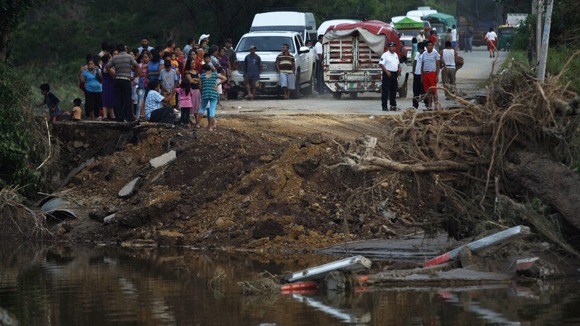 People get out of their cars and gather near a portion of the road.