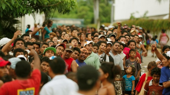 People queue to receive food rations on a flooded beach in Acapulco.