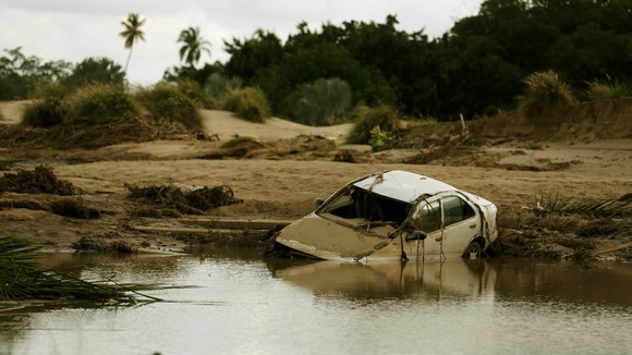 A car lies partially submerged in floodwater on a golf course at a Acapulco hotel.