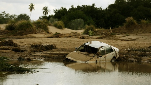 A car lies partially submerged in floodwater on a golf course at a Acapulco hotel.