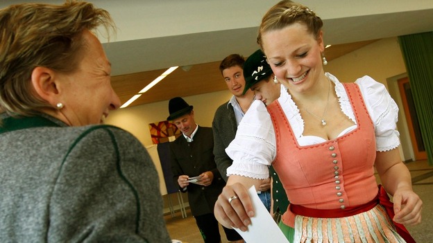 Voter Monika Merk, wearing a traditional Bavarian Dirndl, casts her ballot