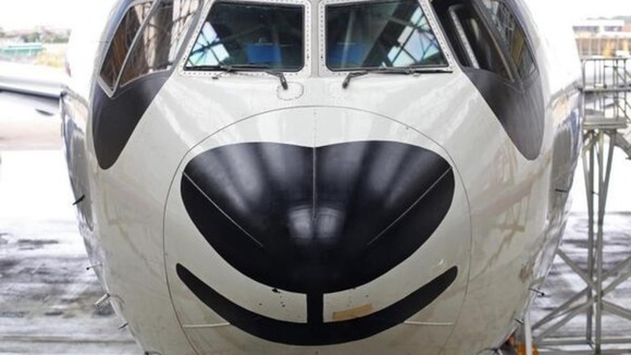 The Boeing 777 smiles for the camera after its paint job