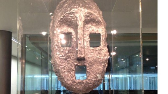 A mask cast in aluminum with square cavities for eyes