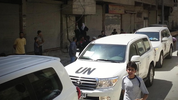 A convoy of UN vehicles is seen driving through the streets of Damascus on August 26.