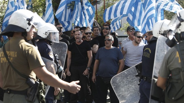 Supporters of extreme-right Golden Dawn party shout slogans outside the Greek police headquarters in Athens