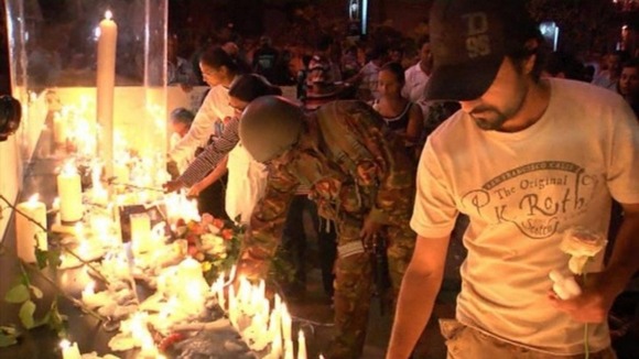A soldier lights a candle at a vigil for attack victims