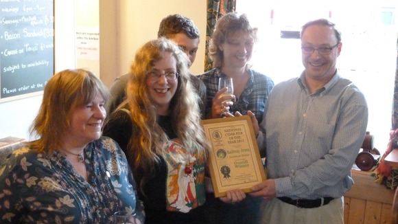 Ian Pinches (far right) and his wife Lesley-Ann being presented with their award from CAMRA