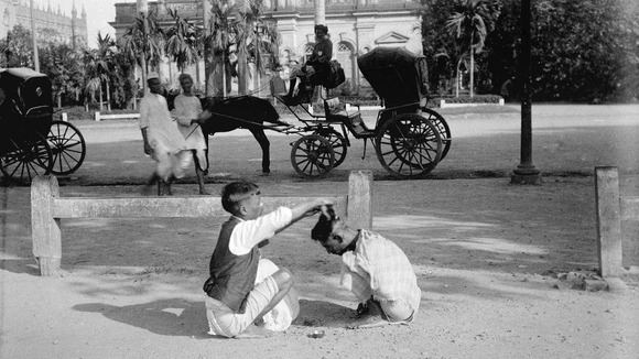 Street hairdresser giving a 'Hindustani haircut' (pudding bowl), Strand Road South, Kolkata