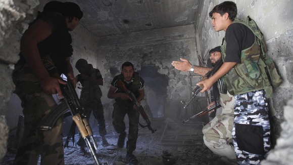 A Free Syrian Army Commander takes cover during a gun battle.