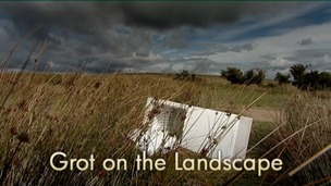 A fridge lying abandoned in the grass