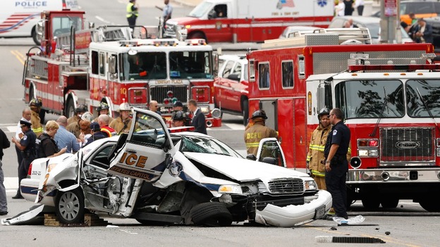 Rescue personnel stand around a smashed US Capitol Hill police vehicle.