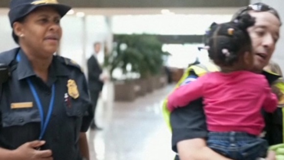 A young girl is carried from the area by security officials