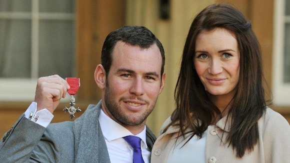 Mark Cavendish, with Peta Todd, holds his MBE at Buckingham Palace
