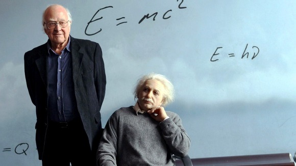 Peter Higgs posing next to a sculpture of Albert Einstein at the CosmoCaixa science museum in Barcelona.