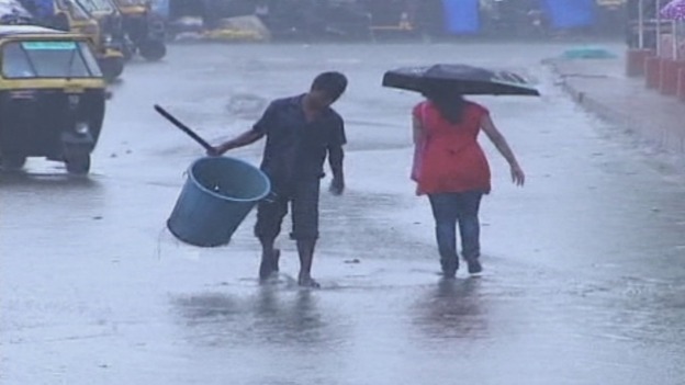 Residents walk through a flooded street