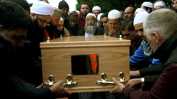 Dr Muhammad Taufiq Al Sattar at the burial of his family, who died in a suspect arson attack.