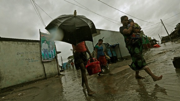 A woman carries her baby as she moves to a safer place with others at the village Donkuru in Srikakulam district.
