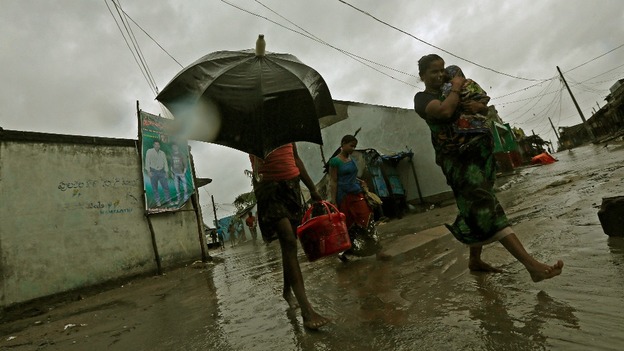 A woman carries her baby as she moves to a safer place with others at the village Donkuru in Srikakulam district.