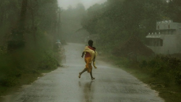 A girl runs for shelter in heavy rain brought by Cyclone Phailin in Ichapuram town in Srikakulam district.
