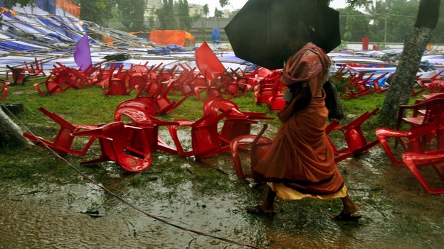 A woman walks past a fallen marquee and chairs set up for a Christian prayer service in Ranchi, India.