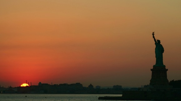 The Statue of Liberty is seen from the Staten Island Ferry as the sun sets.