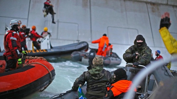 Russian coast guards wearing balaklavas intervene in a Greenpeace protest near an oil rig in the Arctic