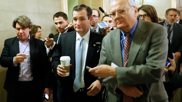 US Senator Ted Cruz (C) is trailed by reporters as he arrives at the Capitol