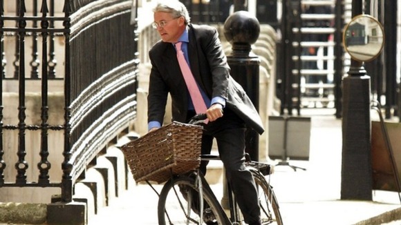 Andrew Mitchell riding on a bike at Downing Street.
