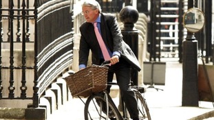Andrew Mitchell riding on a bike at Downing Street.
