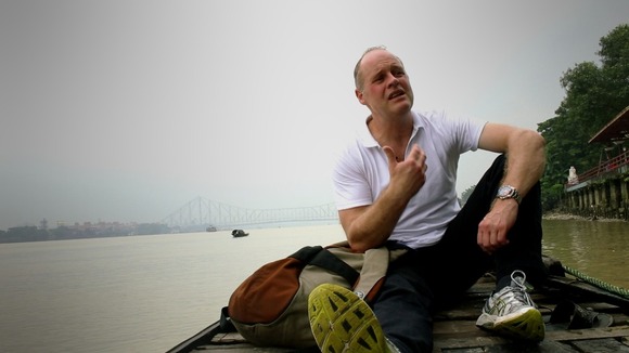 Man sitting on a small boat on a river