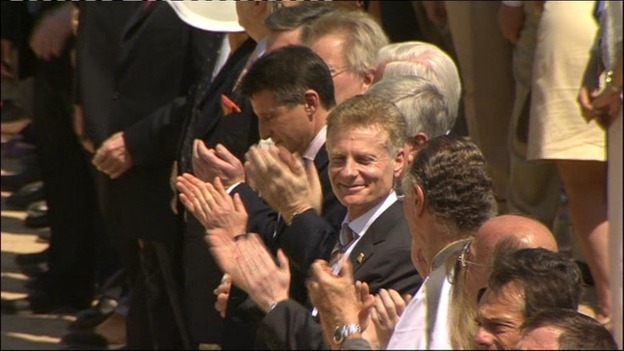 Officials from the London organising committee applaud after the flags are raised.