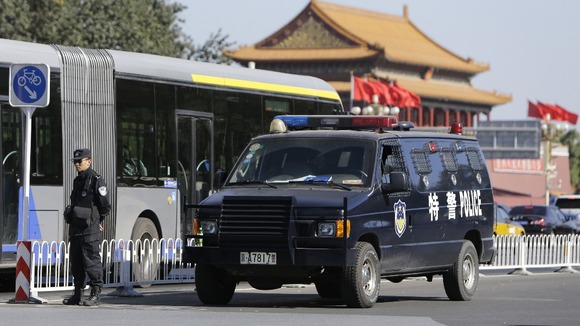 A policeman next to a special police vehicle near Tiananmen Gate