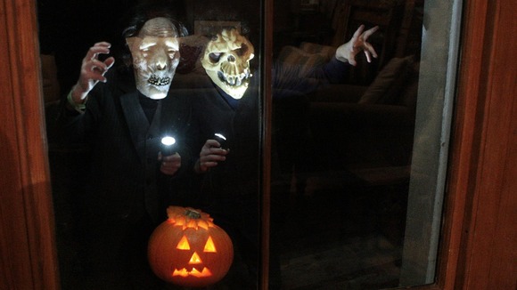Children in Halloween costumes knock on windows.