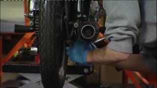 Man in prison working learning trade skills.