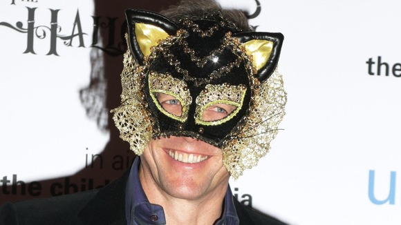Easy option?: Hugh Grant sports an ornate cat mask at he UNICEF Halloween Ball at One Mayfair in London.