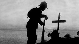 A British soldier pays his respects at the grave of a colleague in 1915.