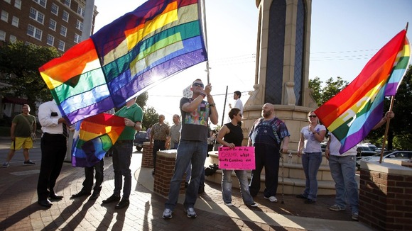 Dale Robinson waves his flag for people driving by a rally of the Dallas LGBT Community to applaud President Obama's stance on Gay marriage