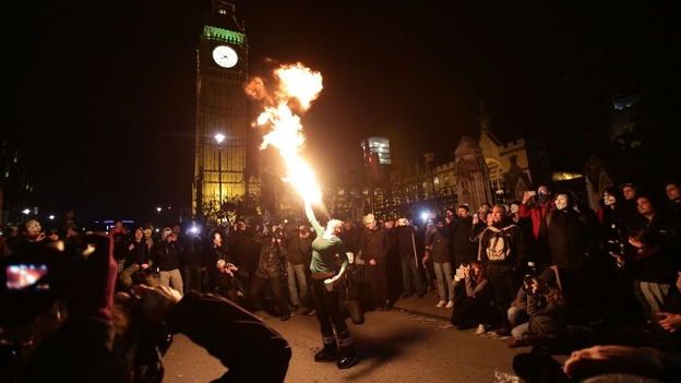A woman breathes fire during the protests outside Westminster.