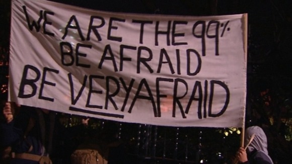 Protesters hold up a banner outside Trafalgar Square