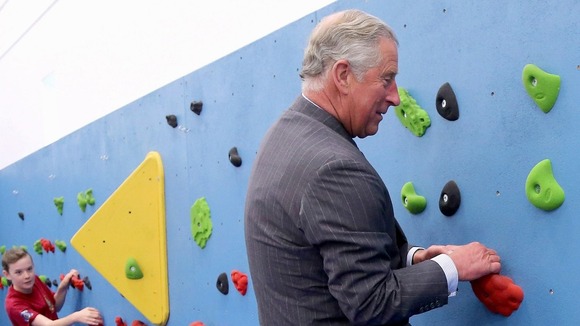 Prince Charles climbing a wall