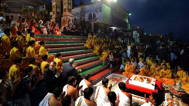 The Prince of Wales and Duchess of Cornwall sit at the top of stairs during their visit to the Hindu holy city of Rishikesh.