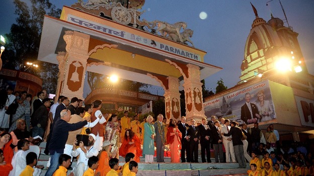 The Prince of Wales and Duchess of Cornwall sit at the top of stairs during their visit to the Hindu holy city of Rishikesh.